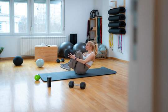 Woman Doing Seated Core Stability Exercise at Home Gym