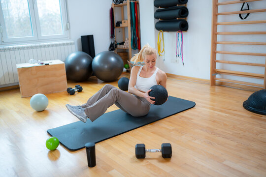 Woman exercises in gym with weights
