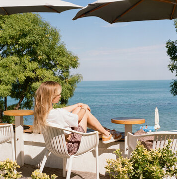 Woman Sitting by Sea View Terrace
