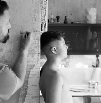 Father Measuring Son&acirc;s Height at Home