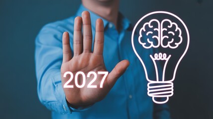 Fototapeta premium 2027 New Year Glowing Brain Bulb Concept with Person in Blue Shirt for Business Planning Creative Goal Setting and Innovative Strategy Development