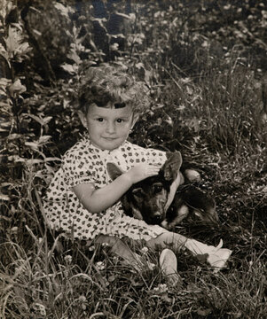 Little Girl Hugging Dog in Garden