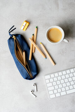 Overhead shot of a working desk with pencils, keyboard and coffee
