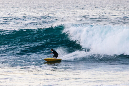 Surfer Riding Along Rolling Swell