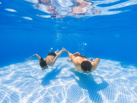 Father and daughter swimming underwater. 