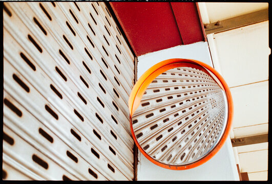 Circle Mirror Reflects Metal Surface in Urban Area