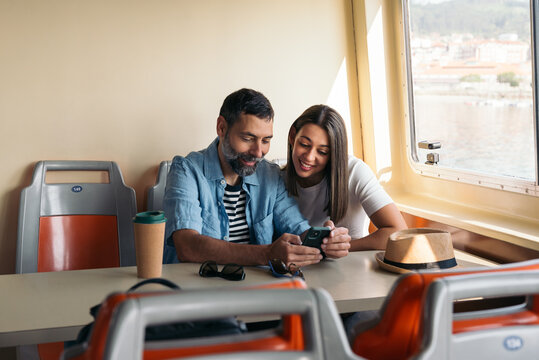 Couple using smartphone during ferry trip