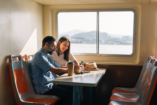 Couple using smartphone during ferry trip