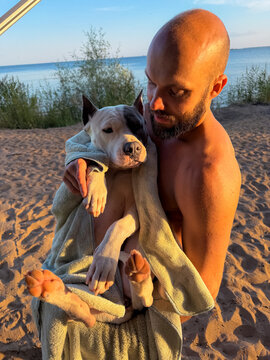 Man Takes Care Of His Dog After Swimming In Summer Lake