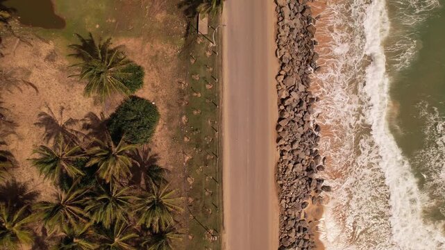 A top-down aerial view of a coastal road running parallel to the ocean.