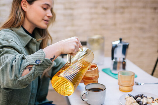 Person pouring cold drink enjoying relaxing afternoon
