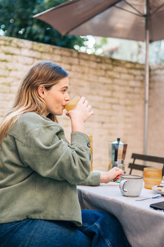 Person enjoying coffee during outdoor afternoon conversation