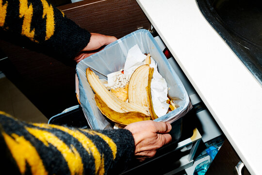 a man pulls out the kitchen food waste bin