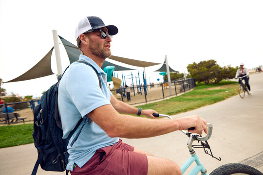 Portrait of a man pedals a bicycle in Venice Beach