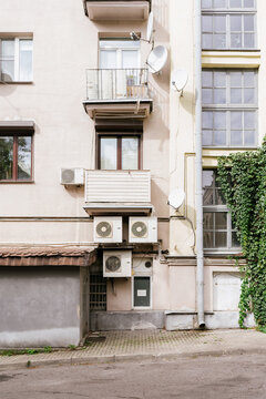 Multi-storey house with air conditioning and satellite dishes.