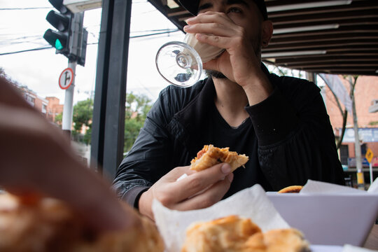 Man Enjoys Baked Goods and Drink at a Cafe in the Afternoon