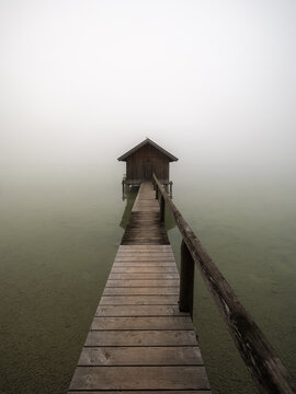 Wooden Pier Leading to Misty Stilt Cabin