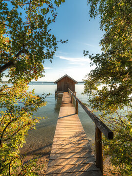 Rustic Wooden Boathouse and Pier at Sunset on a Calm Lake