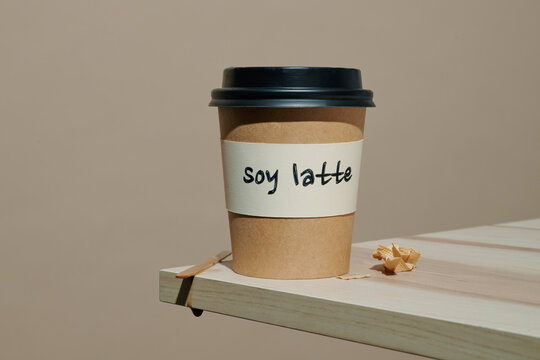 a labeled soy latte cup on a wood ledge