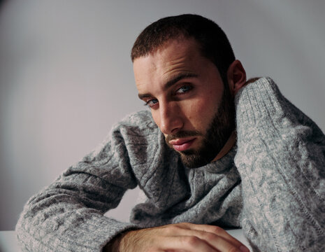 Man With Beard Gazes Thoughtfully While Resting on His Arm