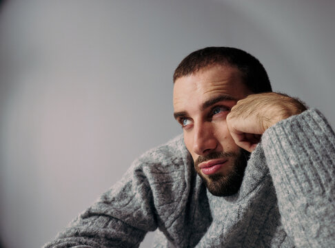 Man Thinks While Resting His Chin on His Hand Indoors