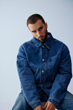Young Man Sitting in Denim Wear With Neutral Background