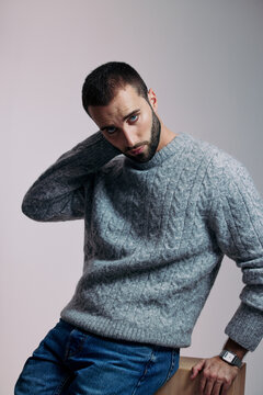 Man Sitting on a Chair in a Gray Sweater With a Serious Look