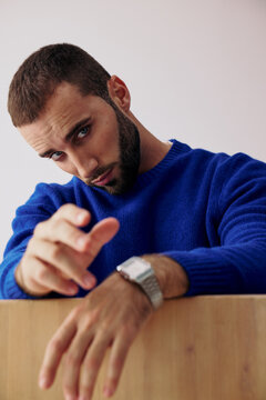 Man Posing With Blue Sweater Against Plain Background