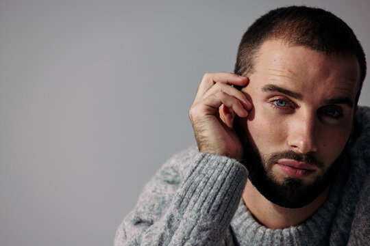 Close up of a Man With a Beard Touching His Face Indoors
