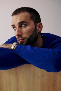 Man With Beard in Blue Sweater Looking Thoughtfully to the Side