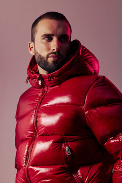 Man Wearing Red Puffy Jacket in Indoor Setting During Photoshoot