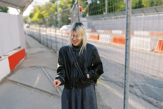 Woman Smiling While Standing Near Construction Site in the City