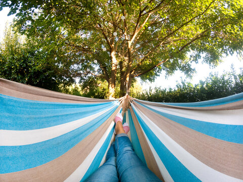 Relaxing in a giant hammock under a tree on vacation. 