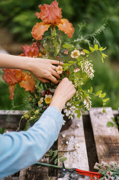 florist outdoors on farm making spring season bouquet 