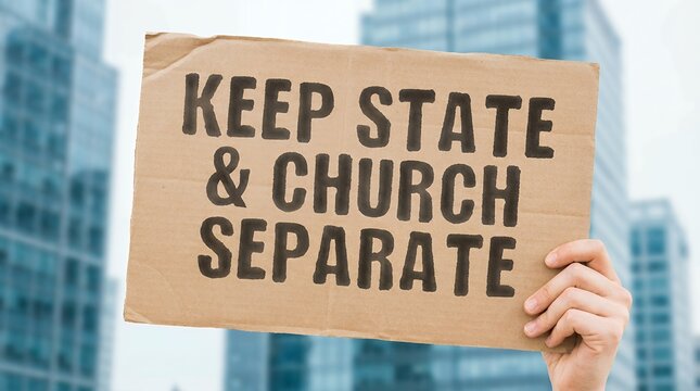 Hand holds cardboard sign with text KEEP STATE CHURCH SEPARATE against blurred city skyline separation church state freedom religion politics religion secularism government