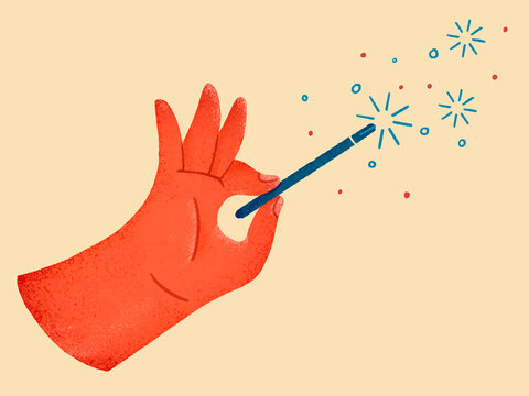 Hand using magic wand creating sparks and stars