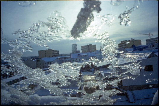 Cold winter landscape, view from a window with a layer of ice