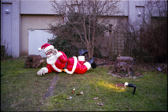 Red Santa Claus sculpture illuminated by a lamp