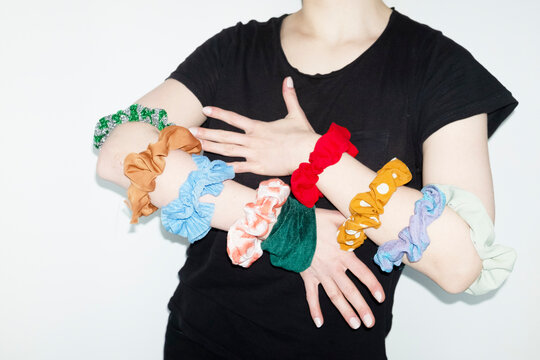 Person having colourful hair accessories in their hands with flashligh