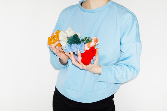 Person having colourful hair accessories in their hands with flashligh