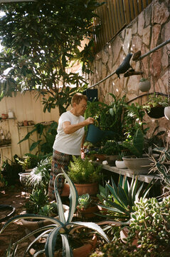 Senior Woman Tending to Succulents in Backyard Garden on Film