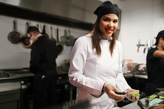 Smiling Female Chef Preparing Avocado in Kitchen