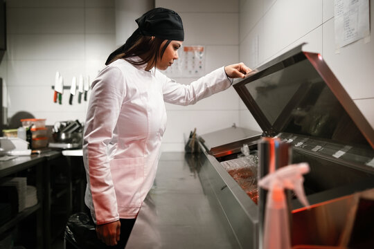 Chef Inspecting Ingredients in Commercial Kitchen Refrigerator