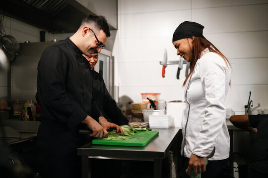 Chefs Collaborating and Smiling While Preparing Food