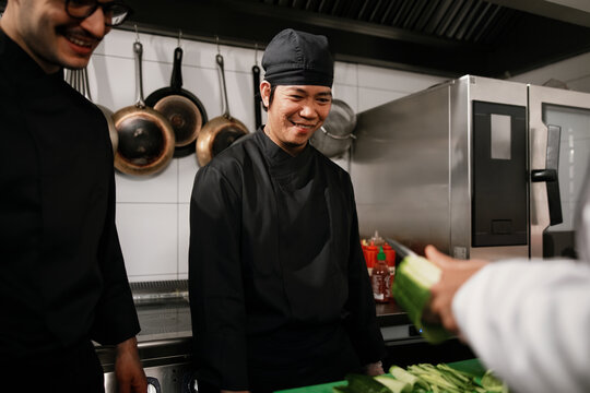 Smiling Chef and Team Working in Professional Kitchen