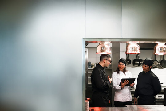 Restaurant Chefs Discussing Service In Professional Kitchen