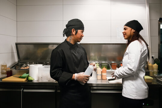 Two Chefs Conversing in Busy Restaurant Kitchen