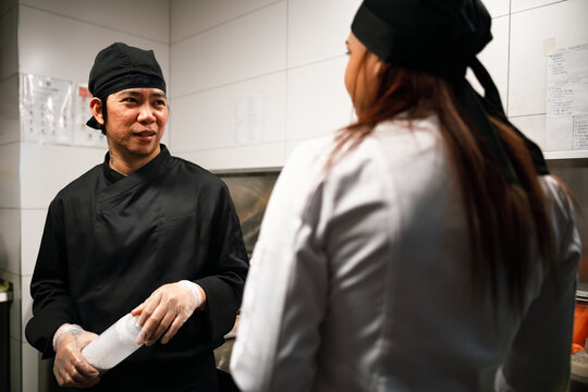 Two Chefs Talking in Professional Restaurant Kitchen