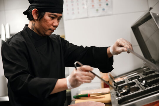 Sushi Chef Preparing Food in Professional Kitchen