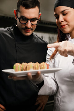 Two Chefs Inspect Sushi Plate in Professional Kitchen